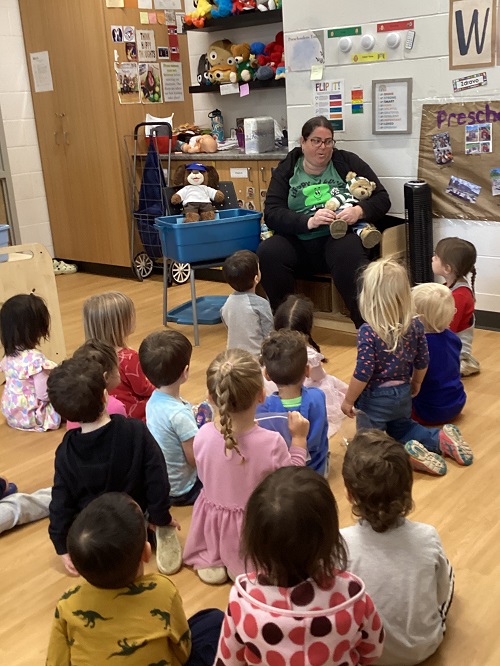 Preschool children sitting around discussing the weather bear