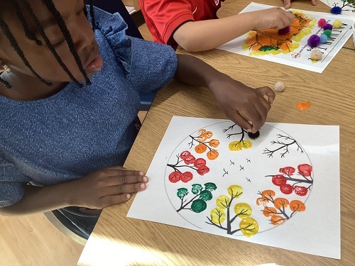 A school age child creating a fall art piece