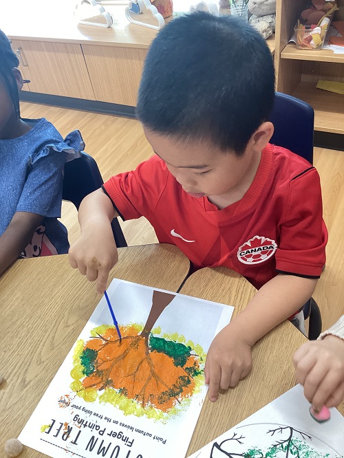 A school age child participating in a fall art experience