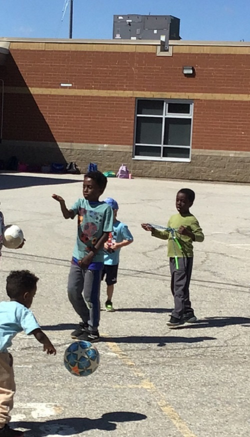 Older school age child leading a game with younger school age children.
