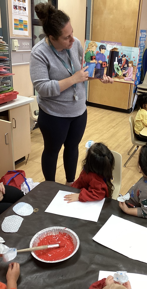 educator showing a book to children