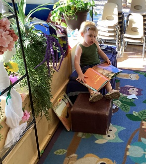 child sitting reading a book in a cozy area