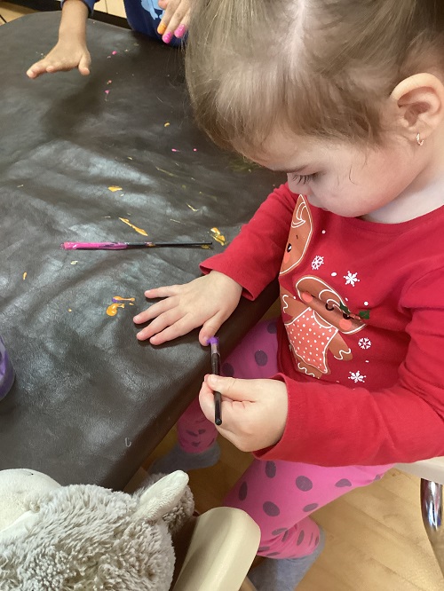 child painting their nails with paint