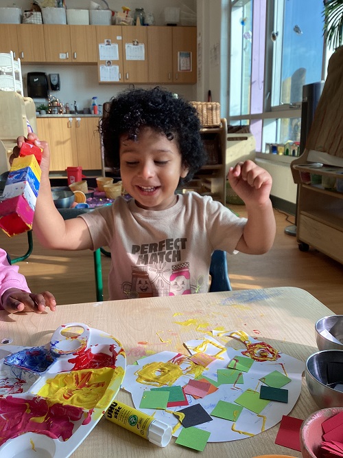 A preschool child excitedly working on their Elmer elephant 