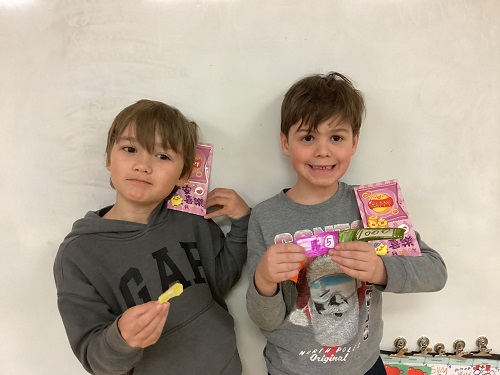 2 boys posing with money envelopes