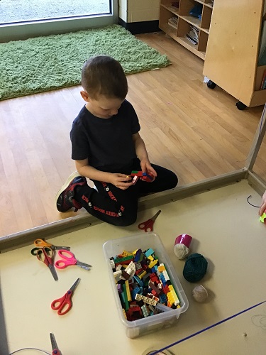 school-age child trying to make zip line with materials