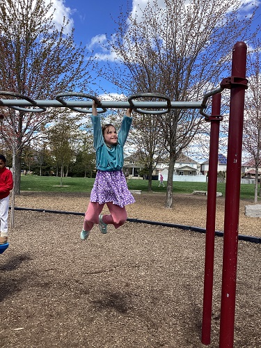 Child swinging on monkeybars