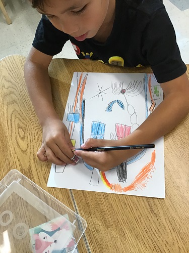 A child drawing a picture of a haunted house