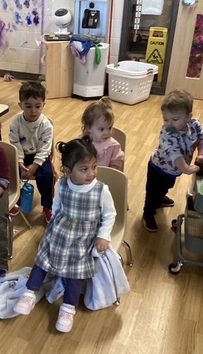 Children sitting on chairs lined up