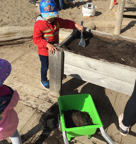 A child digging in the garden box
