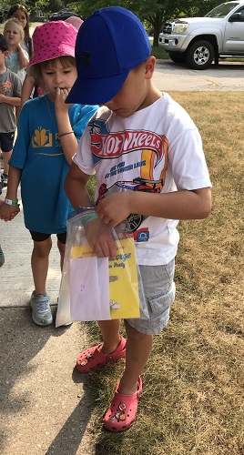 A child reaching into a large ziploc bag 