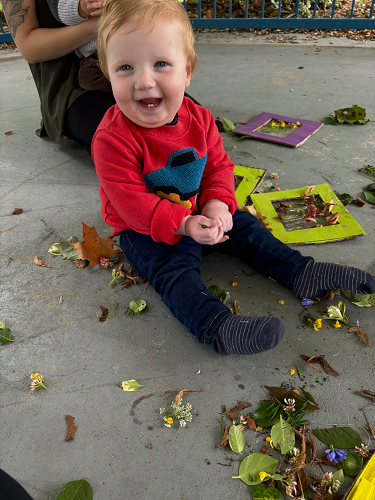 A child sitting in the gazebo using nature items to create artwork