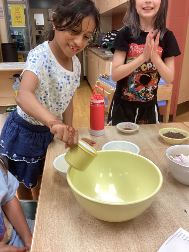 school-age children pouring ingredients in excitedly