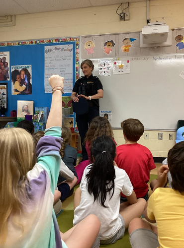 Officer standing in front of school-age group 