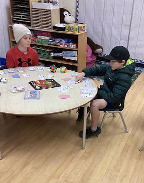 2 School-age boys both playing Solitaire at the same table