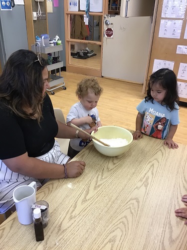 Toddlers making muffins with berries