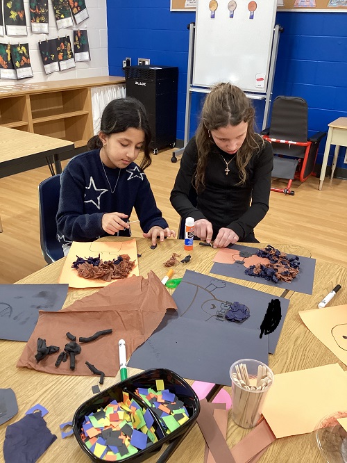 2 school age children working on a creative experience