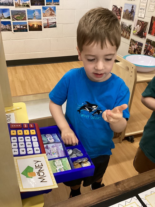 A child looking at money from the cash register.