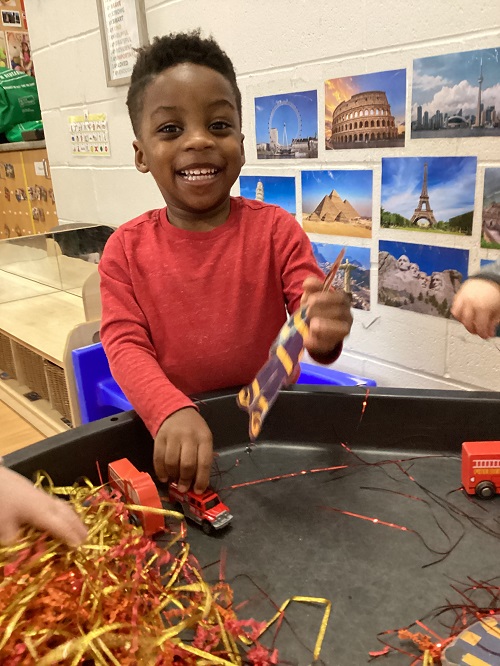 A child engaging in a firefighter themed tuff tray.