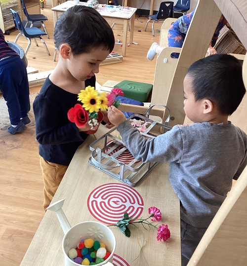 Two children exploring with garden items.