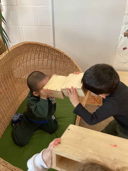 Two children looking at each other through their cameras
