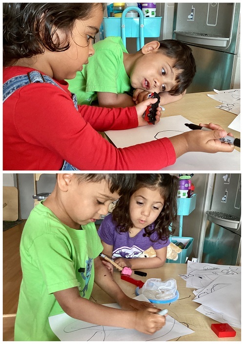 Children sitting and using art materials while drawing.