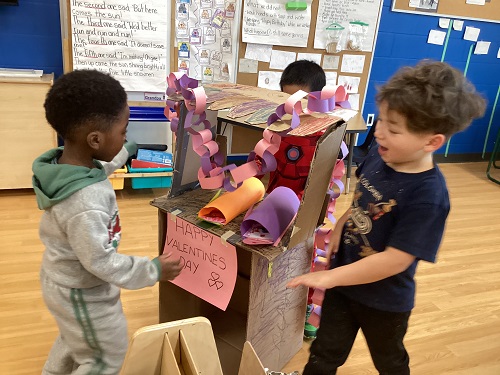A small group of children playing with the post office booth they created