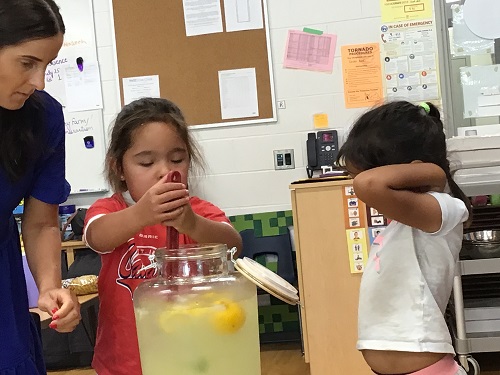 A child making lemonade with an educator.