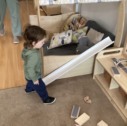 A child setting up a ramp for cars.