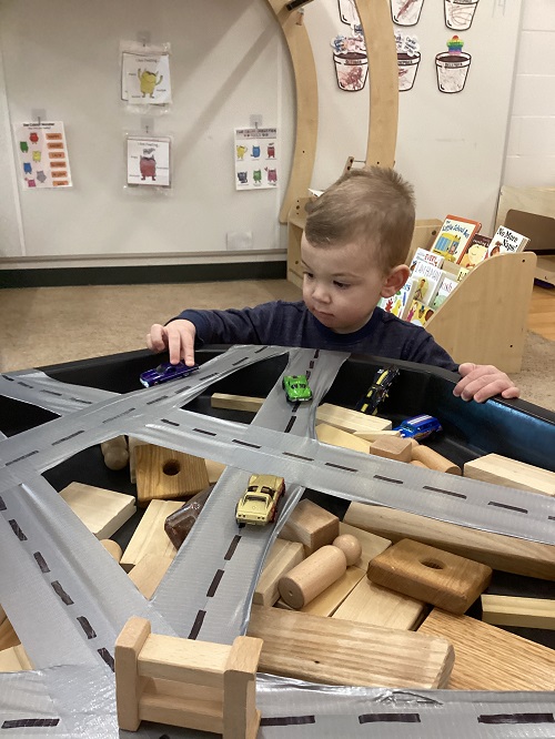 A child exploring with vehicles and tracks