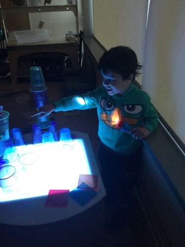 A child exploring lights on a light table