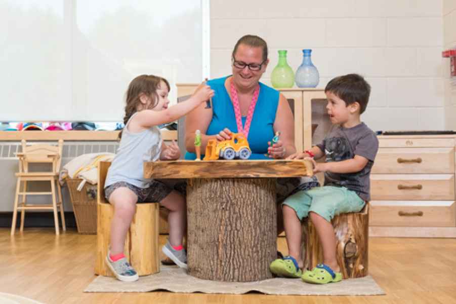 educator playing with preschoolers at a table