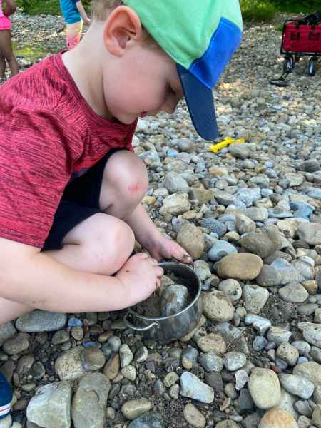 boy mixing stones and dirt in a pot