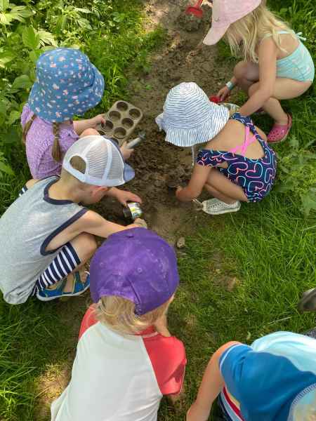 children diggin in the dirt using kitchen tools