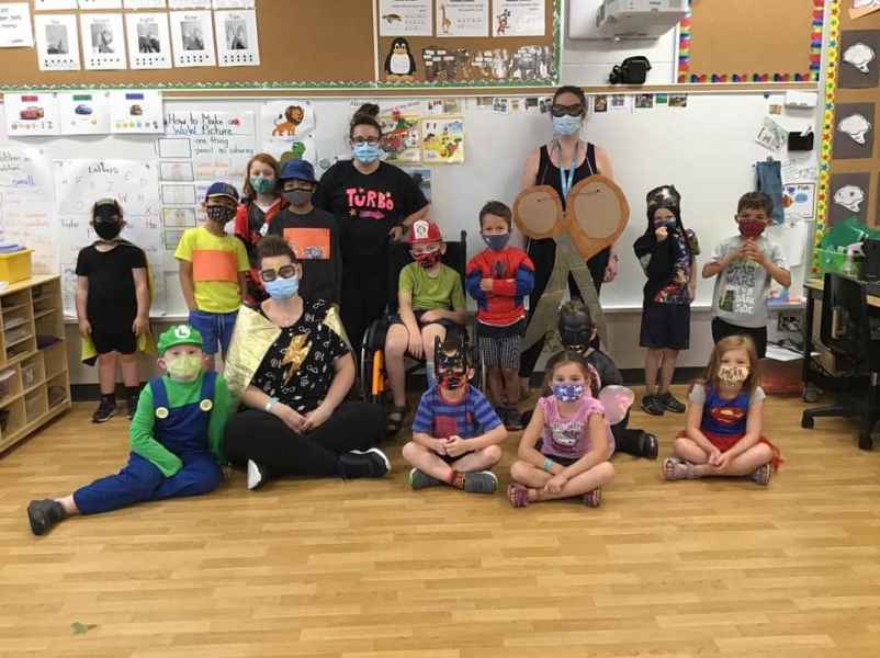 class posing with their superhero costums