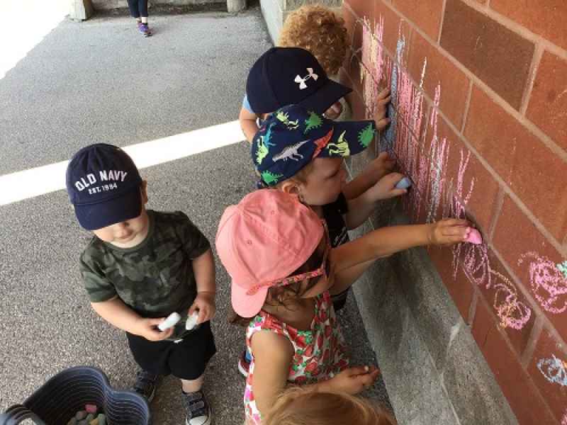 toddlers chalking the wall