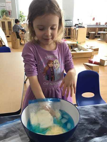 girl doing experiment with ice and cold water