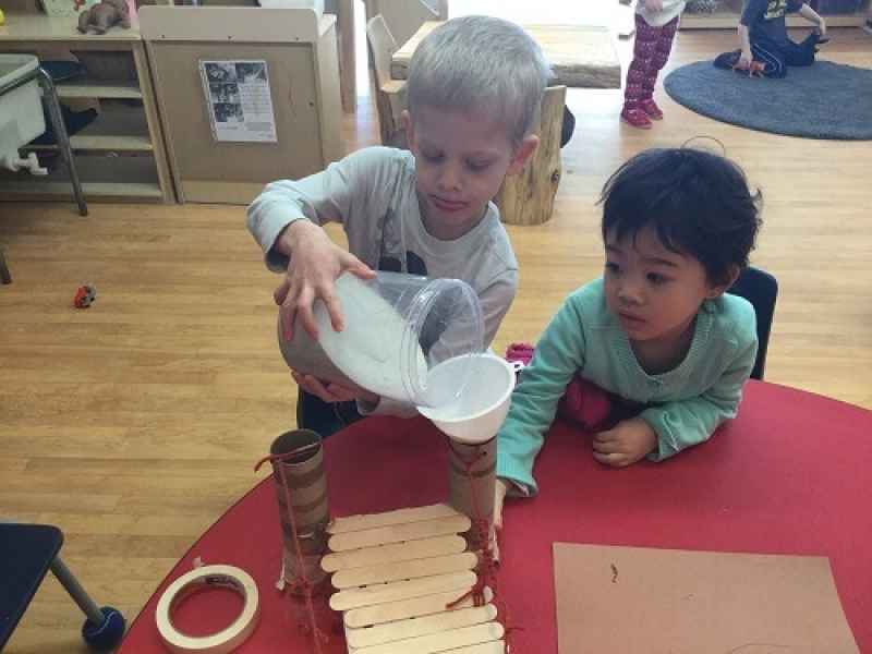 boy pouring sand through a funnel