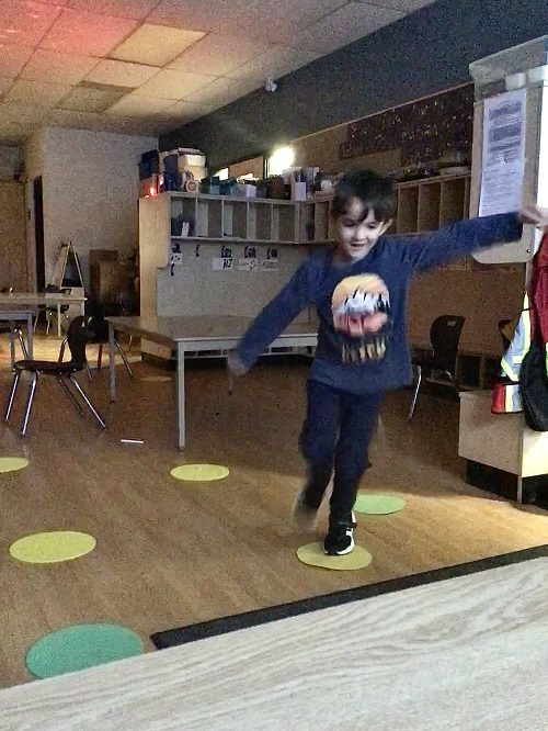 child hopping on coloured circles on the floor