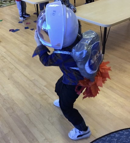 child pretending to be an astronaut  with a helmet and space pack on