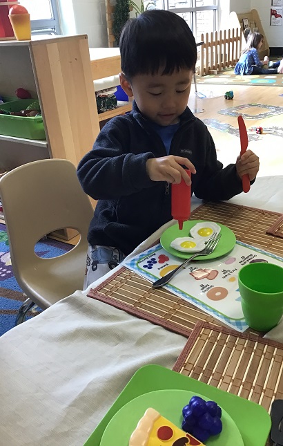 child putting pretend keptchup on his eggs
