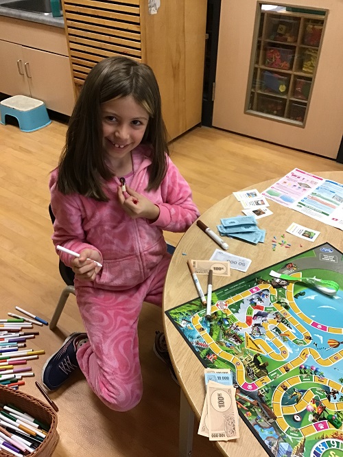 child playing "the Game of Life" board game