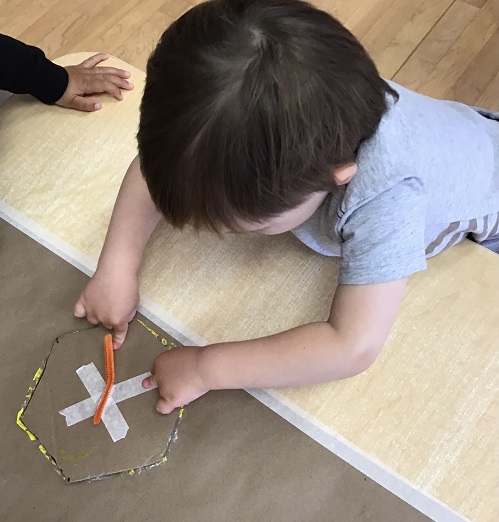 Child pointing to a craft on the table