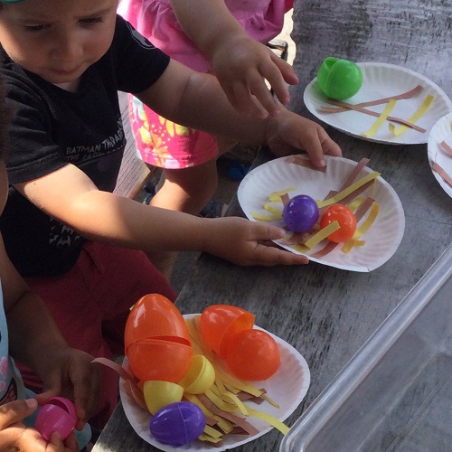 making a pretend bird next on a paper plate