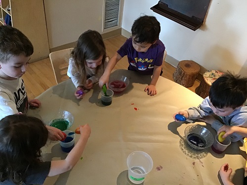 A group of preschoolers are trying to mix oil and water.