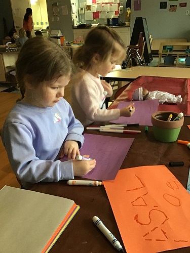 Child holding marker and tracing