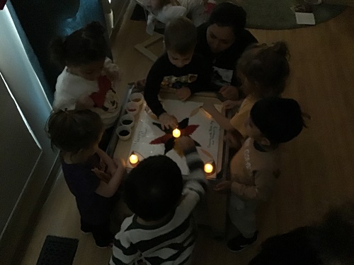 children and Jaspreet looking at the RNGOLI fter placing the tea lights and turning of the lights
