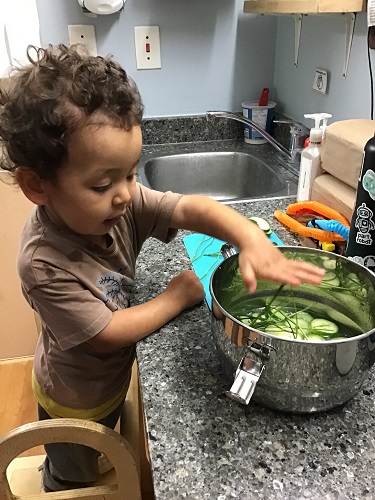 child reaching for the pickles