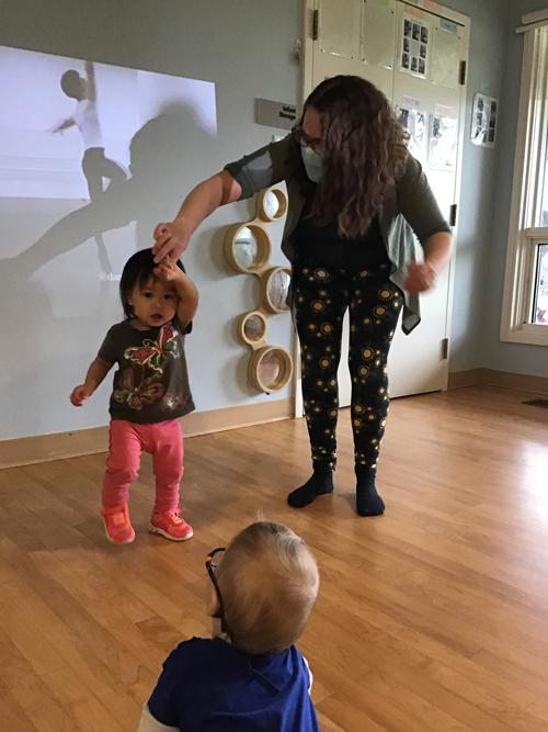 educator assisting a child as they spin like a ballerina