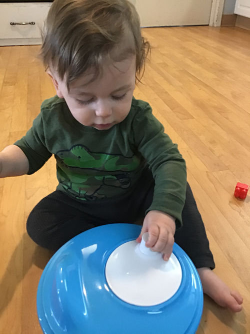 child spinning his toys in a salad spinner